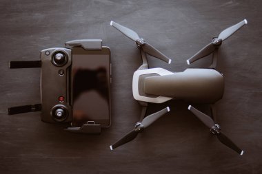 Üstten görünüm uzak ve smartphone makro ayrıntılar. Uzay kopyalayın. Yenilik fotoğraf kavramı. Renk dostum. Siyah bir tabloda yeni bir siyah dron. Dronlar yaşam ve Sanayi kullanarak kavramı.