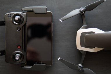 Yenilik fotoğraf kavramı. Renk dostum. Siyah bir tabloda yeni bir siyah dron. Dronlar yaşam ve Sanayi kullanarak kavramı. Üstten görünüm uzak ve smartphone makro yakın ayrıntılar. Kopya alanı.
