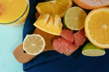 Narenciye, portakal, limon, limon, greyfurt, pomelo vintage yönetim kurulu, limonata ve cam turkuaz bir arka plan üzerine bir bardak suyu