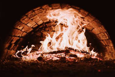 Kömürlerin pizza. Koyu arka plan. Bir yanan fırında pişirme kavramları. Yakın çekim. Fırında yangın.