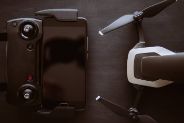 Üstten görünüm uzak ve smartphone makro yakın ayrıntılar. Uzay kopyalayın. Yenilik fotoğraf kavramı. Renk dostum. Siyah bir tabloda yeni bir siyah dron. Dronlar yaşam ve Sanayi kullanarak kavramı.