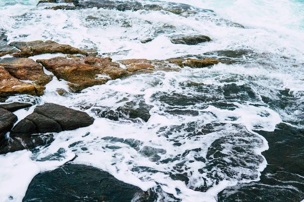 Ondas azuis batendo em uma costa rochosa de perto — Fotografia de Stock