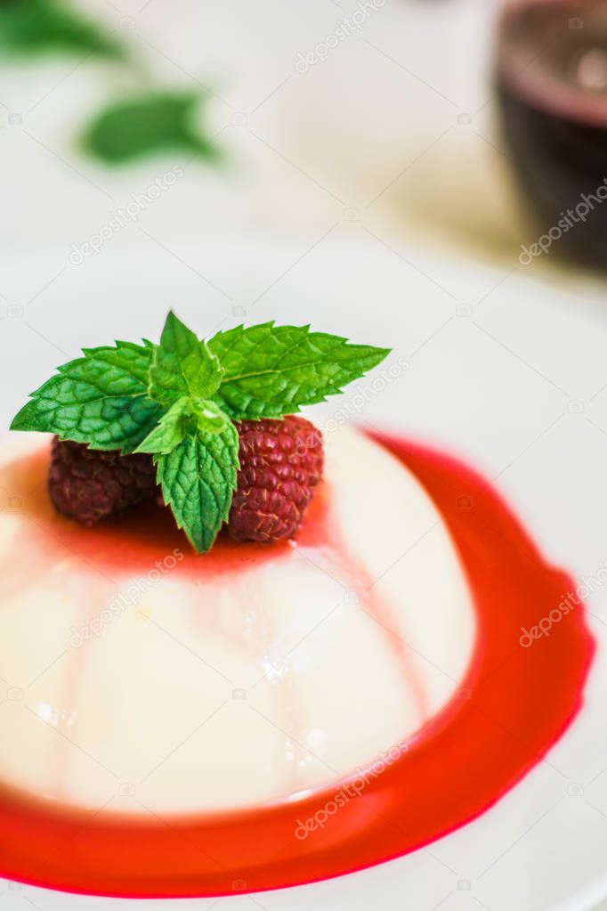 Panakota with raspberries. Vertical shot. Close up top view. Light background. Summer dessert.