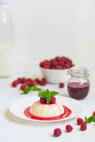 Close up. Panakota with raspberries and mint. Vertical shot. Summer dessert. Light background. — Stock Photo, Image