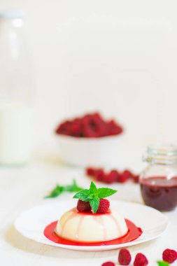 Açık renkli. Ahududu ile panakota. Yakın çekim. Dikey vurdu. Yaz tatlı.
