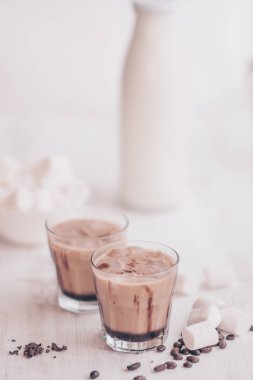 Buzlu kahve. Marshmelow ve kahve fasulye masanın üzerinde. Soğutma içki kavramı. Yaz içeceği. Soğuk kahve süt ve çikolata. Dikey vurdu. Açık renkli.