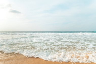 Kumlu sahilde yumuşak mavi okyanus dalgaları. Arkaplan.