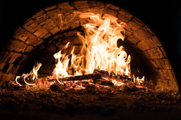 Yakın çekim. Fırında yangın. Kömürlerin pizza. Koyu arka plan. Bir yanan fırında pişirme kavramları.