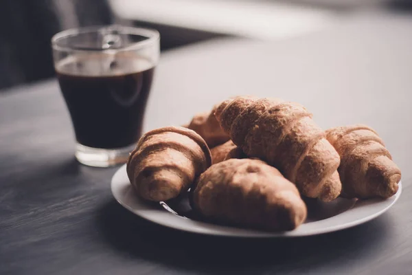 Dessert und Kaffee. das Konzept des Frühstücks. Makroschuss. amerikanischer Kaffee und frische Croissants auf schwarzem Hintergrund. Mate launische Farbe. — Stockfoto