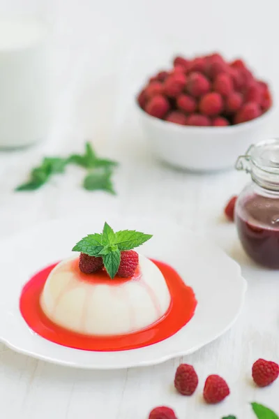 Panakota with raspberries. Light background. Close up. Summer dessert. Vertical shot. — Stock Photo, Image