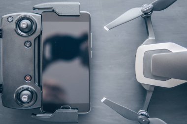 Dronlar yaşam ve Sanayi kullanarak kavramı. Üstten görünüm uzak ve smartphone makro yakın ayrıntılar. Uzay kopyalayın. Yenilik fotoğraf kavramı. Renk dostum. Siyah bir tabloda yeni bir siyah dron.