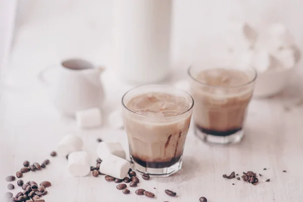 Fondo claro. Café helado. Marshmelow y granos de café en la mesa. Concepto de bebida refrescante. Bebida de verano. Café frío con leche y chocolate . — Foto de Stock