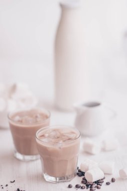 Açık renkli. Buzlu kahve. Soğutma içki kavramı. Marshmelow ve kahve fasulye masanın üzerinde. Yaz içeceği. Soğuk kahve süt ve çikolata ile.