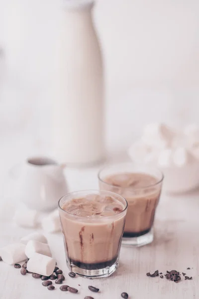 Concepto de bebida refrescante. Bebida de verano. Café frío con leche y chocolate. Disparo vertical. Fondo claro. Café helado. Marshmelow y granos de café sobre la mesa . — Foto de Stock