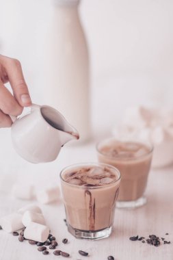 Soğuk kahve süt ve çikolata. Açık renkli. Buzlu kahve. Soğutma içki kavramı. Marshmelow ve kahve fasulye masanın üzerinde. Yaz içeceği.