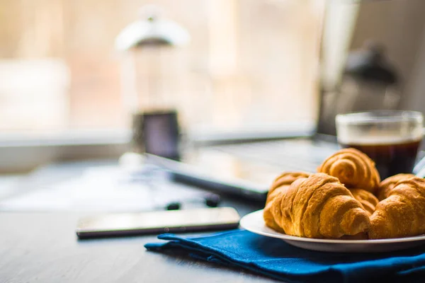 Macro shot of Smartphone and Laptop fresh croissants and coffee black background. Mate moody color. concept of work. — Stock Photo, Image