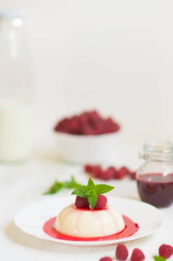 Dikey vurdu. Yaz tatlı. Açık renkli. Ahududu ile panakota. Yakın çekim.