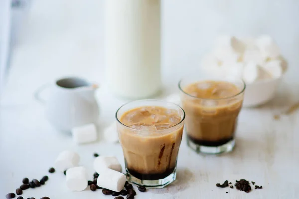 Bebida de verano. Café frío con leche y chocolate. Fondo claro. Café helado. Marshmelow y granos de café en la mesa. Concepto de bebida refrescante . — Foto de Stock