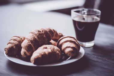 Kahvaltı kavramı. Makro vurdu. Amerikan kahve ve siyah bir zemin üzerine taze kruvasanlar. Moody renk dostum. Tatlı ve kahve.