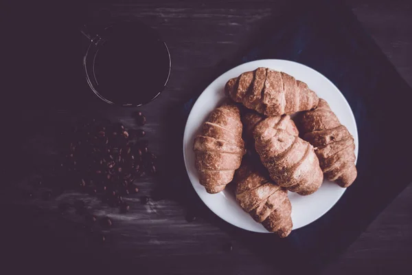 Mate launische Farbe. Frühstückskonzept. Dessert und Kaffeebohnen. Ansicht von oben. Makroaufnahme von frischen Croissants und Kaffee auf schwarzem Hintergrund. — Stockfoto