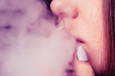 Esrar, elinde esrar Bir kadın sigara içiyor. Siyah arka planda sigara içmek. Tıbbi marihuana kullanımı ve esrar kullanımının yasallaştırılması kavramları. Siyah arka planda Pembe renklendirme