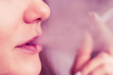Bir kadın sigara esrar esrar, esrar ve onun elinde bir çakmak. Siyah bir arka plan üzerinde duman. Tıbbi esrar kullanım ve yasallaştırma esrar kavramları. Pembe siyah bir arka plan renklendirme