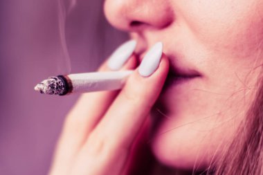 Bir kadın sigara ot esrar esrar ve onun elinde bir çakmak. Siyah bir arka plan üzerinde duman. Tıbbi esrar kullanım ve yasallaştırma esrar kavramları. Pembe siyah bir arka plan renklendirme