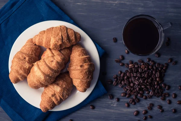 Dessert und Kaffee. Mate launische Farbe. Draufsicht auf frische Croissants und Kaffee auf schwarzem Hintergrund. Makroschuss. das Konzept des Frühstücks. — Stockfoto