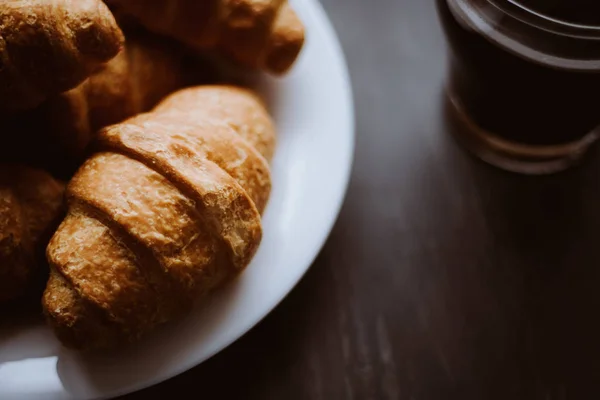 Mate moody color. Dessert and coffee. Macro shot. American coffee and fresh croissants on a black background. The concept of breakfast. — Stock Photo, Image