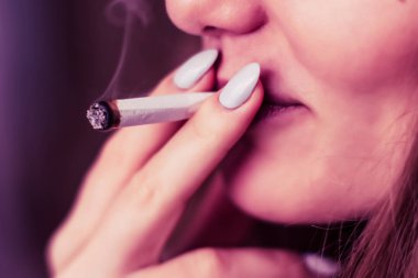 Tıbbi esrar kullanım ve yasallaştırma esrar kavramları. Siyah bir arka plan üzerinde duman. Bir kadın sigara esrar esrar, esrar ve onun elinde bir çakmak. Pembe siyah bir arka plan renklendirme