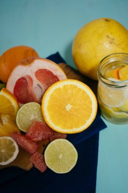 Narenciye, portakal, limon, limon, greyfurt, pomelo vintage yönetim kurulu, limonata ve cam turkuaz bir arka plan üzerine bir bardak suyu