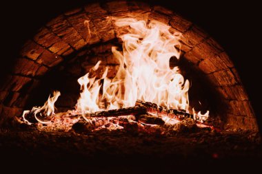 Yakın çekim. Fırında yangın. Kömürlerin pizza. Koyu arka plan. Bir yanan fırında pişirme kavramları.