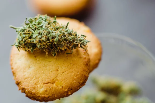 Cookies with marijuana. Sweets with cannabis. Cannabis buds on a black background. Baking with the addition of CBD. Sweets with weed. — Stock Photo, Image