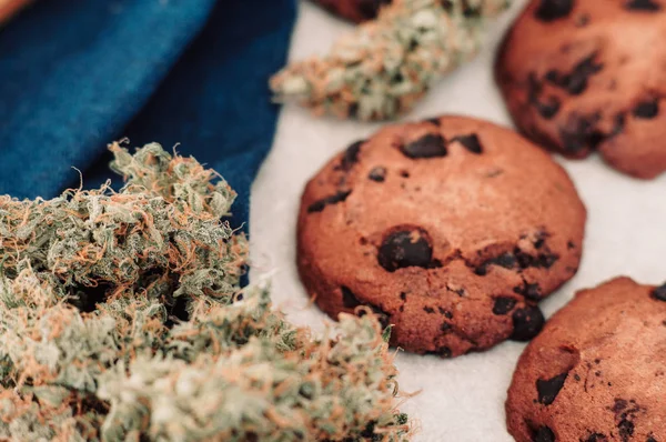 Dolci con erba. Biscotti al cioccolato con marijuana. Dolci con cannabis. Gemme di cannabis su sfondo nero. Cottura con l'aggiunta di CBD. macro — Foto Stock