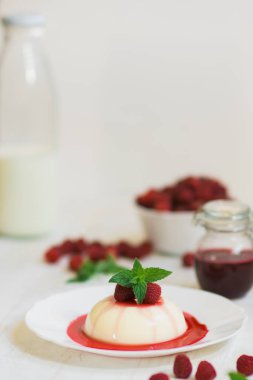 Dikey vurdu. Yakın çekim. Açık renkli. Yaz tatlı. Ahududu ile panakota.