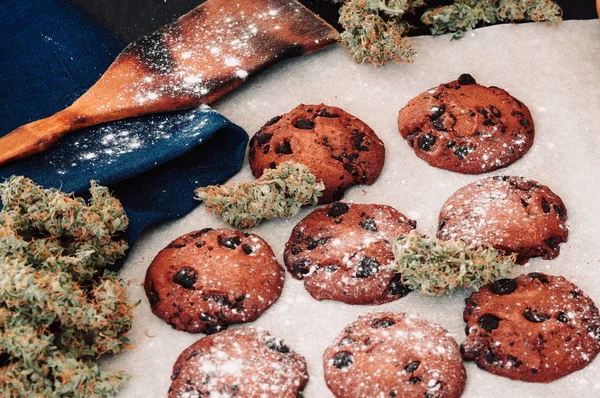 Godis med cannabis. Cannabis knoppar på en svart bakgrund. Bakning med tillägg av Cbd. godis med ogräs. Choklad cookies med marijuana. makro — Stockfoto