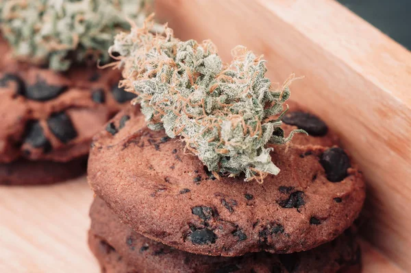 Chocolade koekjes met marihuana. Snoep met cannabis. De toppen van de cannabis op een zwarte achtergrond. Bakken met de toevoeging van Cbd. snoep met onkruid. macro — Stockfoto