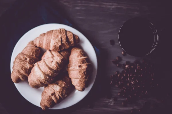 Dessert und Kaffee. Makroschuss. Mate launische Farbe. frische Croissants und Kaffee auf schwarzem Hintergrund. das Konzept des Frühstücks. — Stockfoto