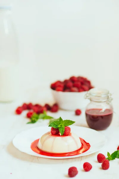 Light background. Close up. Panakota with raspberries and mint. Vertical shot. Summer dessert. — Stock Photo, Image
