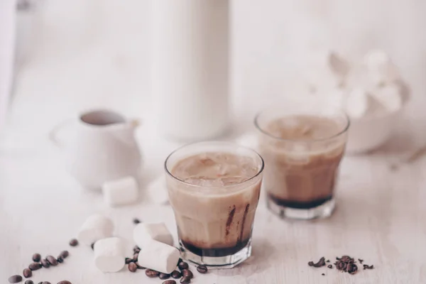 Concepto de bebida refrescante. Bebida de verano. Café frío con leche y chocolate. Fondo claro. Café helado. Marshmelow y granos de café sobre la mesa . — Foto de Stock