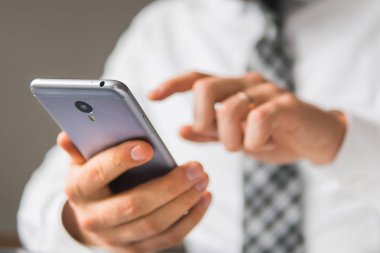 Açık renkli. Bir dizüstü bilgisayar ile ofis işleri. Akıllı telefon elinde tutuyor. İş adamı iş bilgisayar ile ofis işleri tablo. Genç işadamı sakallı. Mali iş.