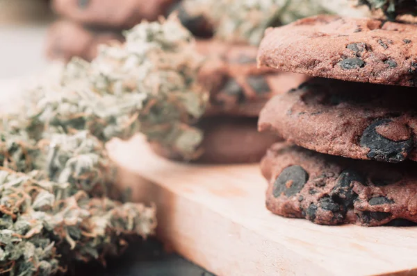 Bakken met de toevoeging van Cbd. snoep met onkruid. Chocolade koekjes met marihuana. Snoep met cannabis. De toppen van de cannabis op een zwarte achtergrond. macro — Stockfoto