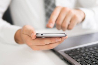 İş adamı iş bilgisayar ile ofis işleri tablo. Akıllı telefon elinde tutuyor. Mali iş. Bir dizüstü bilgisayar ile ofis işleri.