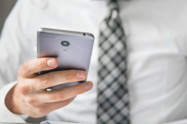 Bir dizüstü bilgisayar ile ofis işleri. Akıllı telefon elinde tutuyor. İş adamı iş bilgisayar ile ofis işleri tablo. Genç işadamı sakallı. Mali iş. Açık renkli.