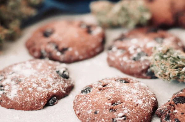 Bakken met de toevoeging van Cbd. snoep met onkruid. Chocolade koekjes met marihuana. Snoep met cannabis. Cannabis toppen op een zwarte achtergrond. — Stockfoto