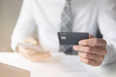 İşadamı kredi kartı ve bir akıllı telefon kullanır. Online ödeme. Online alışveriş. Hareket eden telefon. Office iş kavramı. Telefonu kapatın. Işık sızıntıları