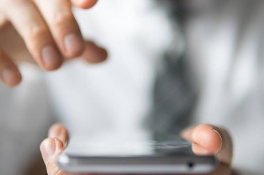 Mali iş. Bir dizüstü bilgisayar ile ofis işleri. İş adamı iş bilgisayar ile ofis işleri tablo. Açık renkli. Smartphone elinde. Yakın çekim. Genç işadamı sakallı. 