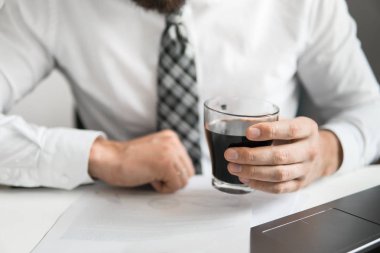 İşadamı ofis işleri ile bilgisayar ofis işleri tablo. Genç işadamı sakallı. Bir dizüstü bilgisayar ile çalışır. Açık renkli. Mali iş.