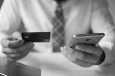 Malların online ödeme. Online ödeme telefon aracılığıyla. Akıllı telefon ve Internet ticareti. Online Döviz Alım Satım ticaret. Onun elinde banka kredi kartıyla genç işadamı.