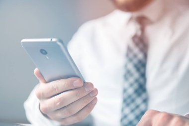 Bir dizüstü bilgisayar ile ofis işleri. Açık renkli. Yakın çekim. İş adamı iş bilgisayar ile ofis işleri tablo. Smartphone el genç işadamı sakallı. Mali iş.